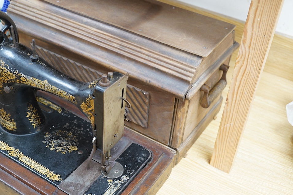 An early 20th century cased Singer sewing machine, 46cm wide at base. Condition - poor